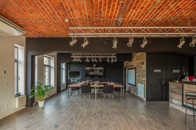 Le Loft Industrial avec plafond en briques rouges et tables en salle de classe